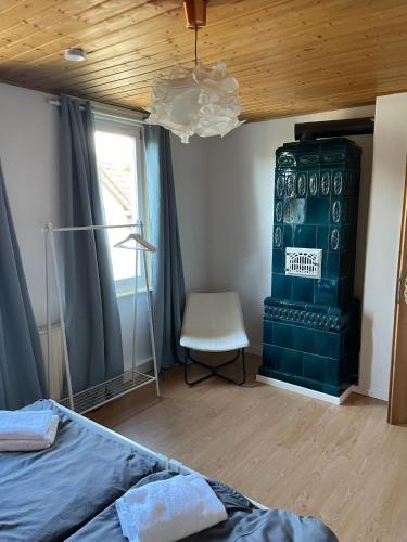 a bedroom with a bed and a chair and a ceiling at Leopold's Apartments mit Garten und Vesteblick Mitten in Coburg in Coburg
