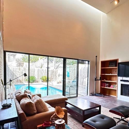 a living room with a couch and a pool at Chic In The City in Houston