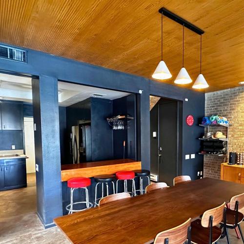 a kitchen with a large wooden table and red stools at Chic In The City in Houston