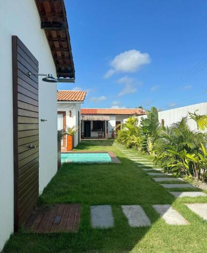 a backyard with a pool and a house at Vila Mandakaru in São Miguel do Gostoso