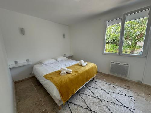 une chambre avec un lit avec deux serviettes dessus dans l'établissement La Rose des vents aux pieds des plages, à Palavas-les-Flots