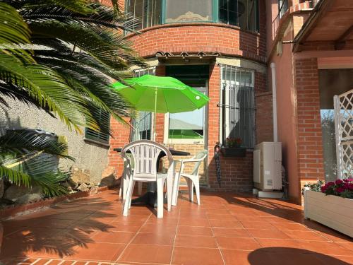 a table and two chairs with an umbrella on a patio at Agrihome Di Alberto Giuseppe Gulotta B&B Bella Vista Appartamento Salvia in Massarosa