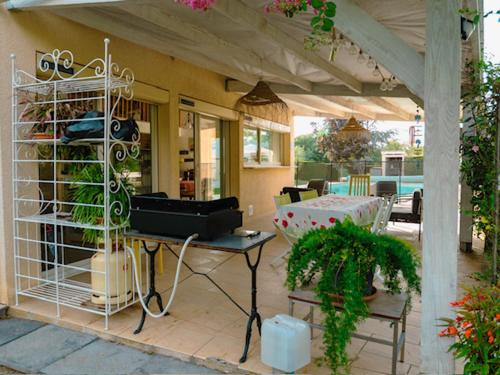 Cette maison dispose d'une terrasse avec une table et des plantes. dans l'établissement Maison de vacances, à Coufouleux