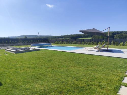 a swimming pool in a yard with green grass at Echappée des Hirondelles in Richemont