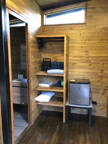 a small room with a computer in a wooden cabin at Cabaña tipo glamping en finca cafetera con zonas verdes, avistamiento de aves, paisaje cafetero in San Francisco