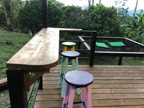 two colorful stools sitting next to a wooden table at Cabaña tipo glamping en finca cafetera con zonas verdes, avistamiento de aves, paisaje cafetero in San Francisco