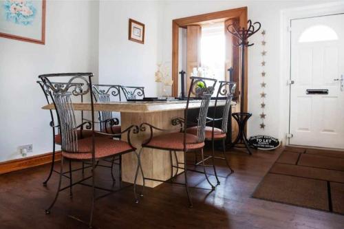 a kitchen with a table and chairs in a room at Commerce Cottage Rooms in Ripley