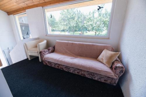 a couch sitting in a room with a window at Penzion BAVI in Kotvrdovice