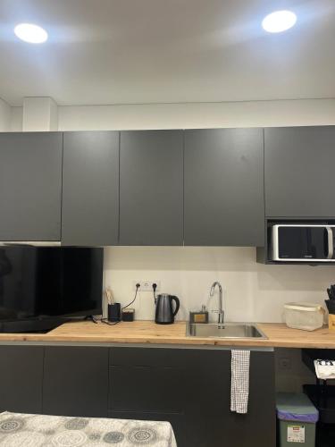 a kitchen with gray cabinets and a sink at Friend's House in Maia