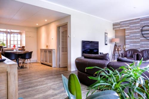 a living room with a couch and a table at Waterhill's Bed & Wellness in Dinteloord
