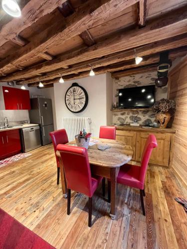 une cuisine avec une table en bois et des chaises rouges dans l'établissement Appartement Esprit Chalet 71m², à Briançon