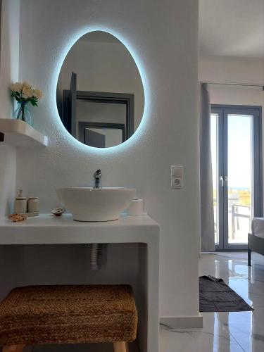 a white bathroom with a sink and a mirror at Cledari Plaka Appartments in Plaka