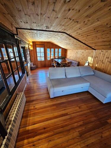 un soggiorno con un divano bianco in una stanza con pavimenti in legno di Nest in Crest a Champoluc