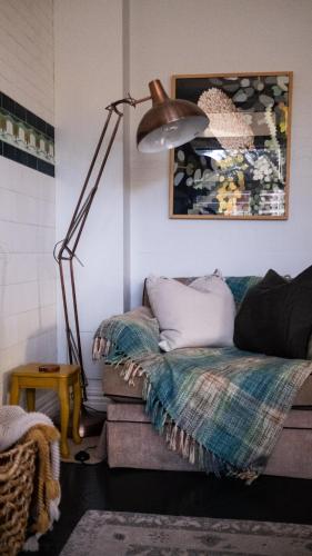 a living room with a couch and a lamp at Charming Vintage Flat near Newtown. 11am checkout. in Sydney