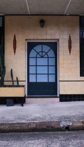 a building with a black door and a window at Charming Vintage Flat near Newtown. 11am checkout. in Sydney