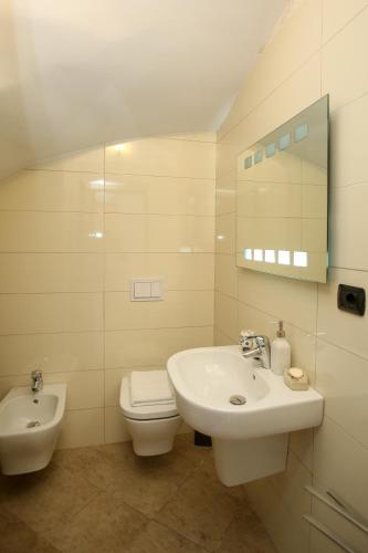 a white bathroom with a sink and a toilet at Dapaj Luxury Residence in Vlorë