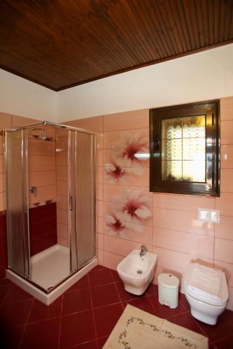 a bathroom with a shower and a toilet and a sink at Dapaj Luxury Residence in Vlorë