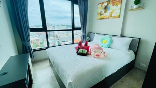 a bedroom with a bed with two stuffed animals on it at The base Central Pattaya 338 by Numam in Pattaya
