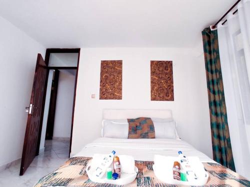 a bedroom with a bed with two containers on it at The Crooner Lounge in Nairobi