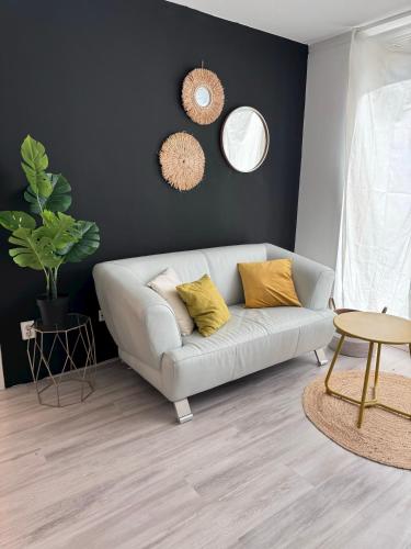 a living room with a white couch with yellow pillows at Short stay klimop in Nijmegen