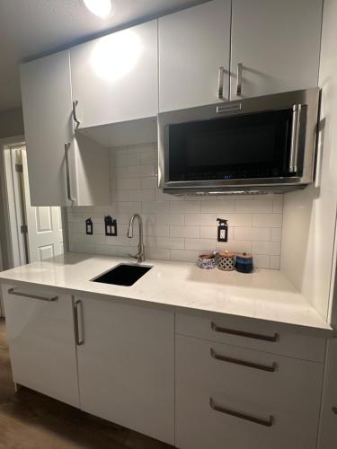 a white kitchen with a sink and a microwave at YoBee! Park Reservation Included! Heart of Yosemite - Homey Studios and Breakfast in Yosemite West