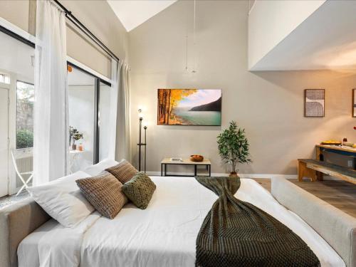 a bedroom with a white bed and a large window at Artist's Tower Townhome Just Renovated w Loft in Gainesville
