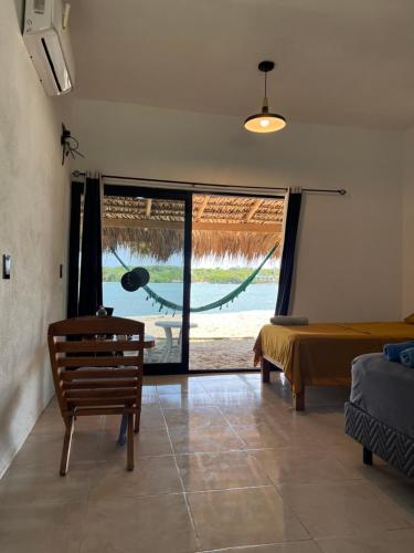 a room with a bed and a window with a hammock at Cabañas Laguna Azul in Chamuscadero