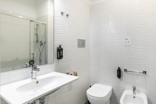 a white bathroom with a sink and a toilet at B&B Hotels Park Hotel Suisse Santa Margherita Ligure in Santa Margherita Ligure