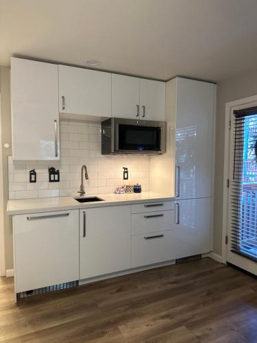 a kitchen with white cabinets and a sink and a microwave at YoBee! Park Reservation Included! Heart of Yosemite - Homey Studios and Breakfast in Yosemite West