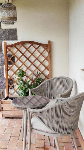 eine Terrasse mit einem Tisch, 2 Stühlen und einem Tisch in der Unterkunft Studio neuf dans maison avec vue sur la chaine des puys in Riom