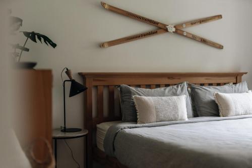 a bedroom with a bed with a wooden stick on the wall at La Halte Mont-Blanc Ski in out in Saint-Faustin