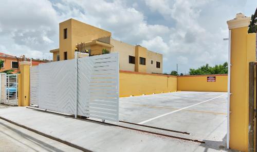 a gate in a parking lot in front of a building at BNB Family Vacation Rentals, Corales del Sur, Santo Domingo Este in La Viva