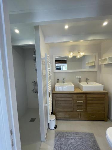 une salle de bain avec deux lavabos et un miroir dans l'établissement Maison de Vacances des Centaurées, à La Guérinière