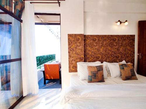 a bedroom with a white bed with a wooden headboard at The Crooner Lounge in Nairobi