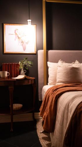 a bedroom with a bed and a table with a plant at Charming Vintage Flat near Newtown. 11am checkout. in Sydney