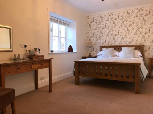 a bedroom with a bed and a desk and a window at 17 Burgate in Pickering