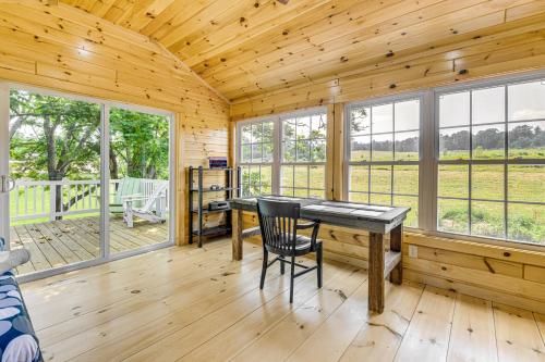 a wooden cabin with a desk and chairs in a room with windows at Adirondacks Cottage with Countryside Views! in Moriah