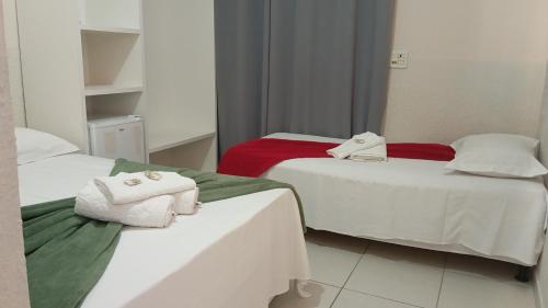 two beds with towels on them in a room at Pousada Piri carvalho in Pirenópolis