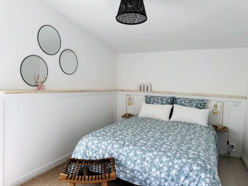 une chambre avec un lit et deux miroirs au mur dans l'établissement Charmante maison aux Sables, à Les Sables-dʼOlonne