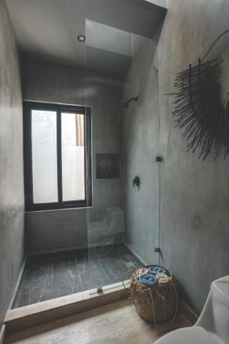 a bathroom with a shower with a window and a tub at Urbano by Sundara in Tulum