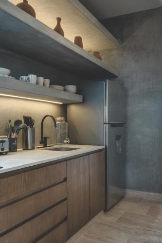 a kitchen with a sink and a refrigerator at Urbano by Sundara in Tulum