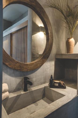 a bathroom with a mirror and a sink at Urbano by Sundara in Tulum