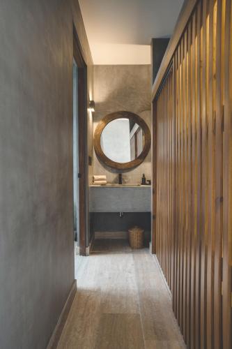 a hallway with a mirror and a sink in a bathroom at Urbano by Sundara in Tulum