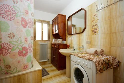 a bathroom with a washing machine and a sink at Rustico in borgo Polcenigo in Polcenigo