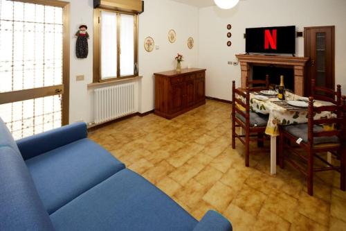 a living room with a blue couch and a table at Rustico in borgo Polcenigo in Polcenigo