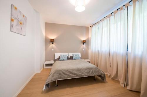 une chambre avec un lit et une grande fenêtre dans l'établissement Maison contemporaine Mittelhausbergen, à Mittelhausbergen