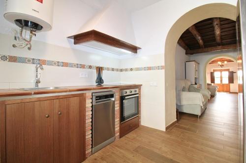 a kitchen with a sink and a stove at El Pintaillo by SIERRA VIVA in Cortelazor