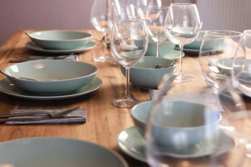 a wooden table with plates and glasses of wine at Akrotiri Sea View Maisonette in Akrotiri
