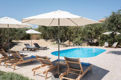 a pool with chairs and umbrellas next to at Akrotiri Sea View Maisonette in Akrotiri