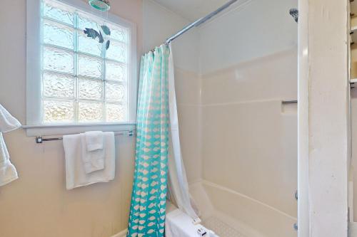 a bathroom with a shower and a shower curtain at No Regrets Up in Emerald Isle